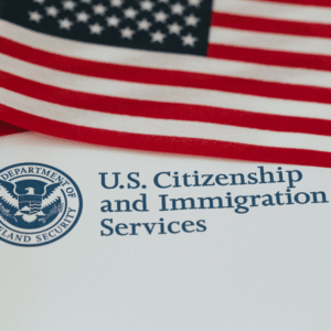 Navigating New Citizenship Rules: What Trump’s Executive Orders Mean for Surrogacy Blog Post Image 081426 - Conceptual Options Surrogacy Agency and Egg Donation Agency - Conceptual Options Surrogacy Agency and Egg Donation Agency U.S. flag draped above a document that shows the text 'U.S. Citizenship and Immigration Services' and the agency seal.